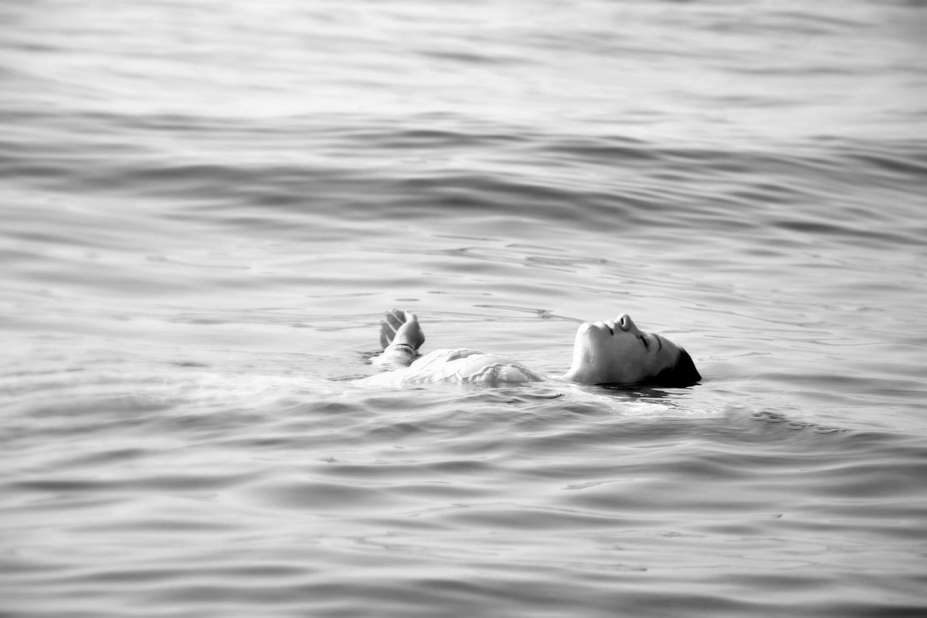 woman swimming in water on back